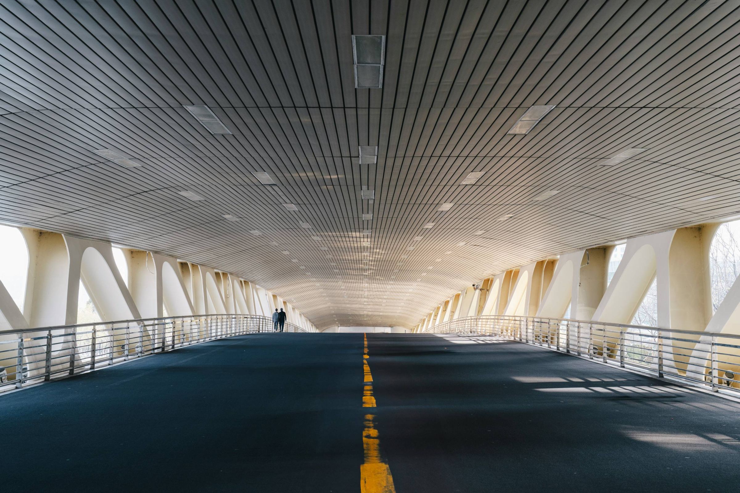 Covered steel walkway with a yellow center line stretching into the distance