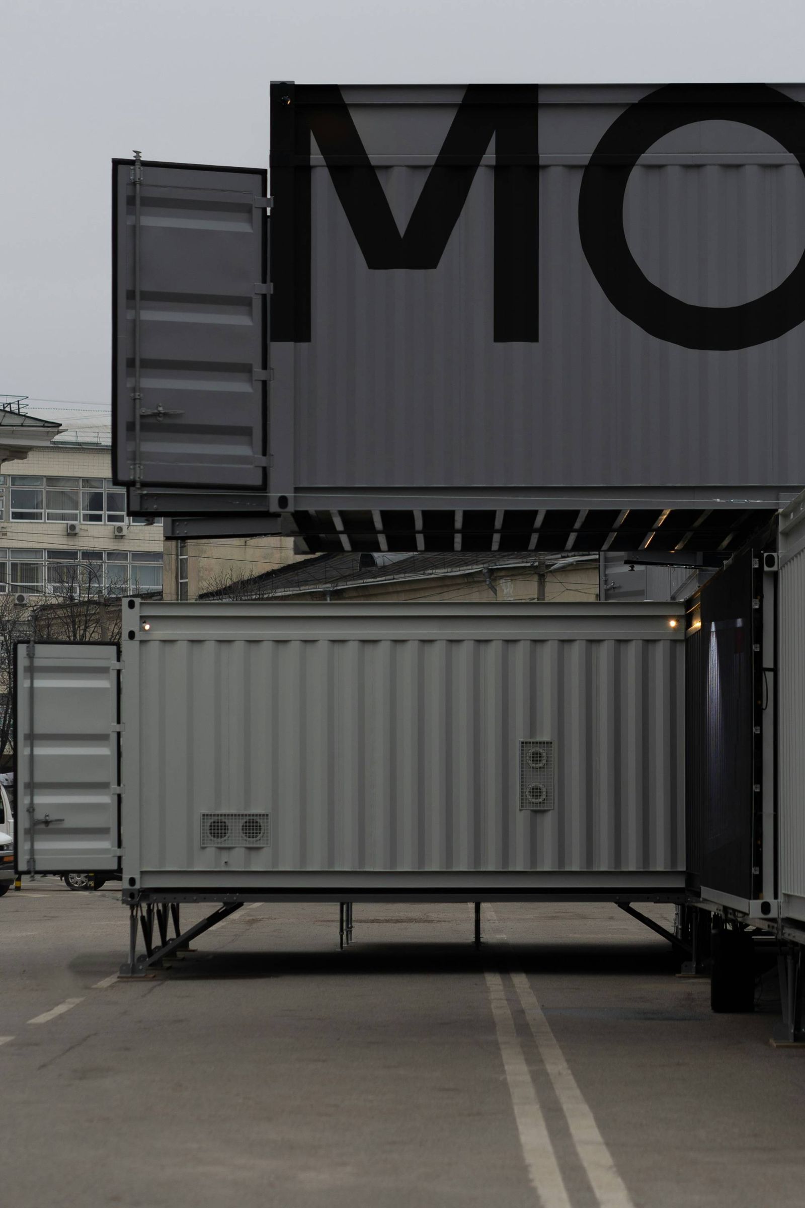 Gray shipping containers stacked two high on a city street