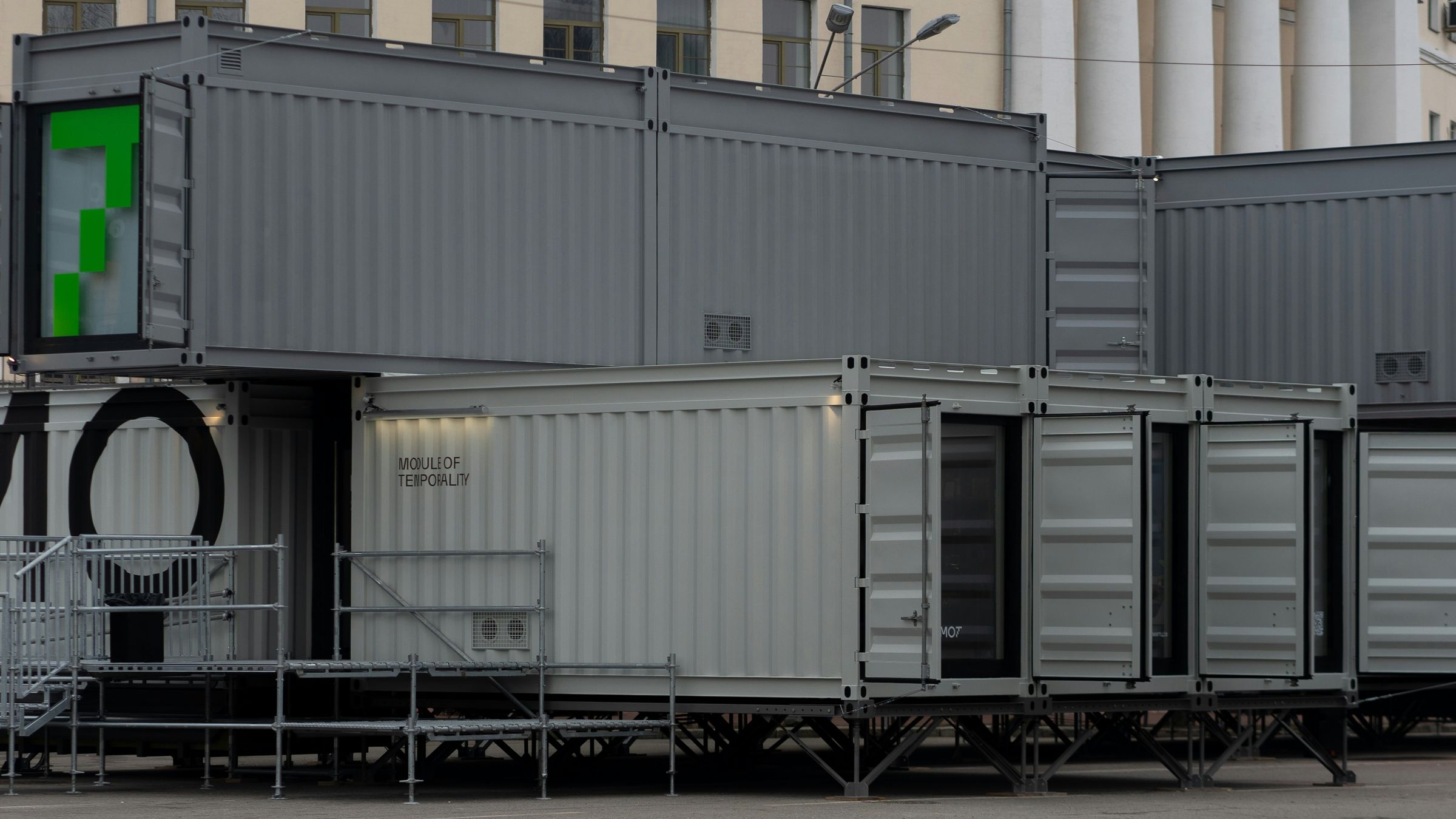 Gray shipping containers stacked and converted into modular buildings