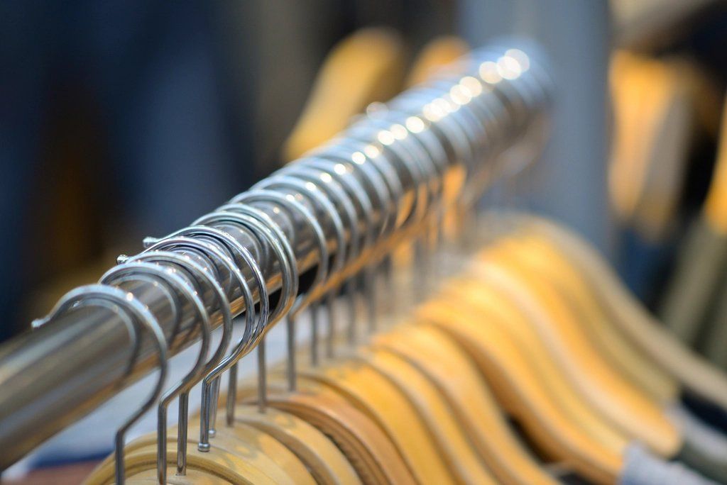 Clothes hangers lined up on a rail in a clothing store