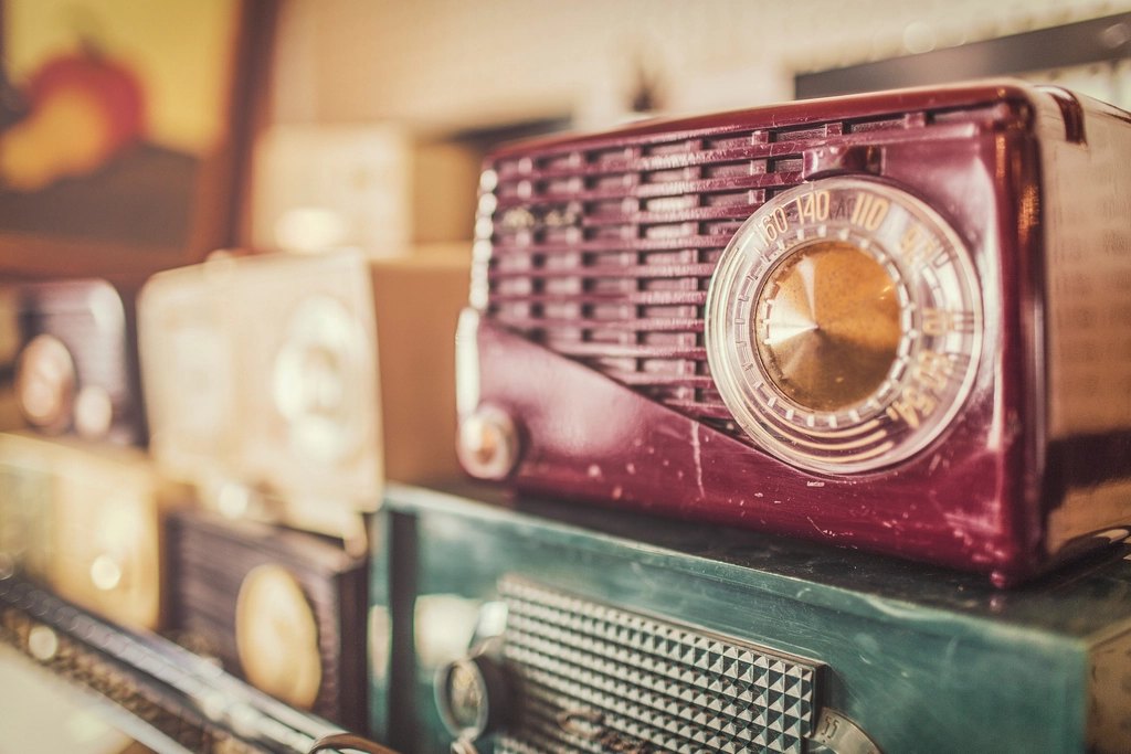 A vintage burgundy radio among other retro radios