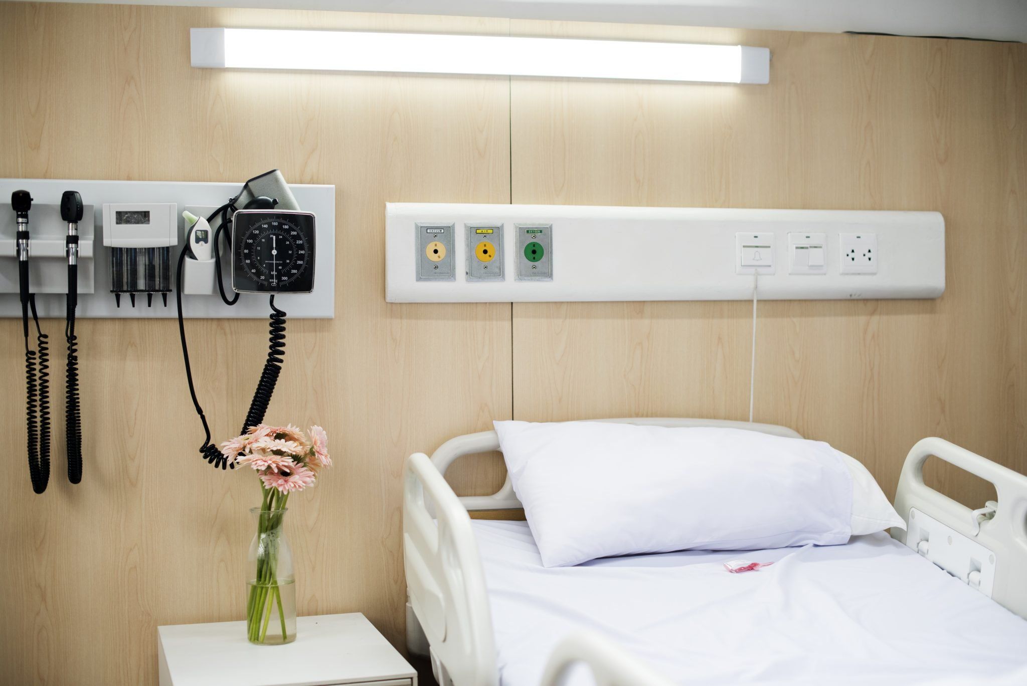 A hospital bed with wall-mounted medical equipment
