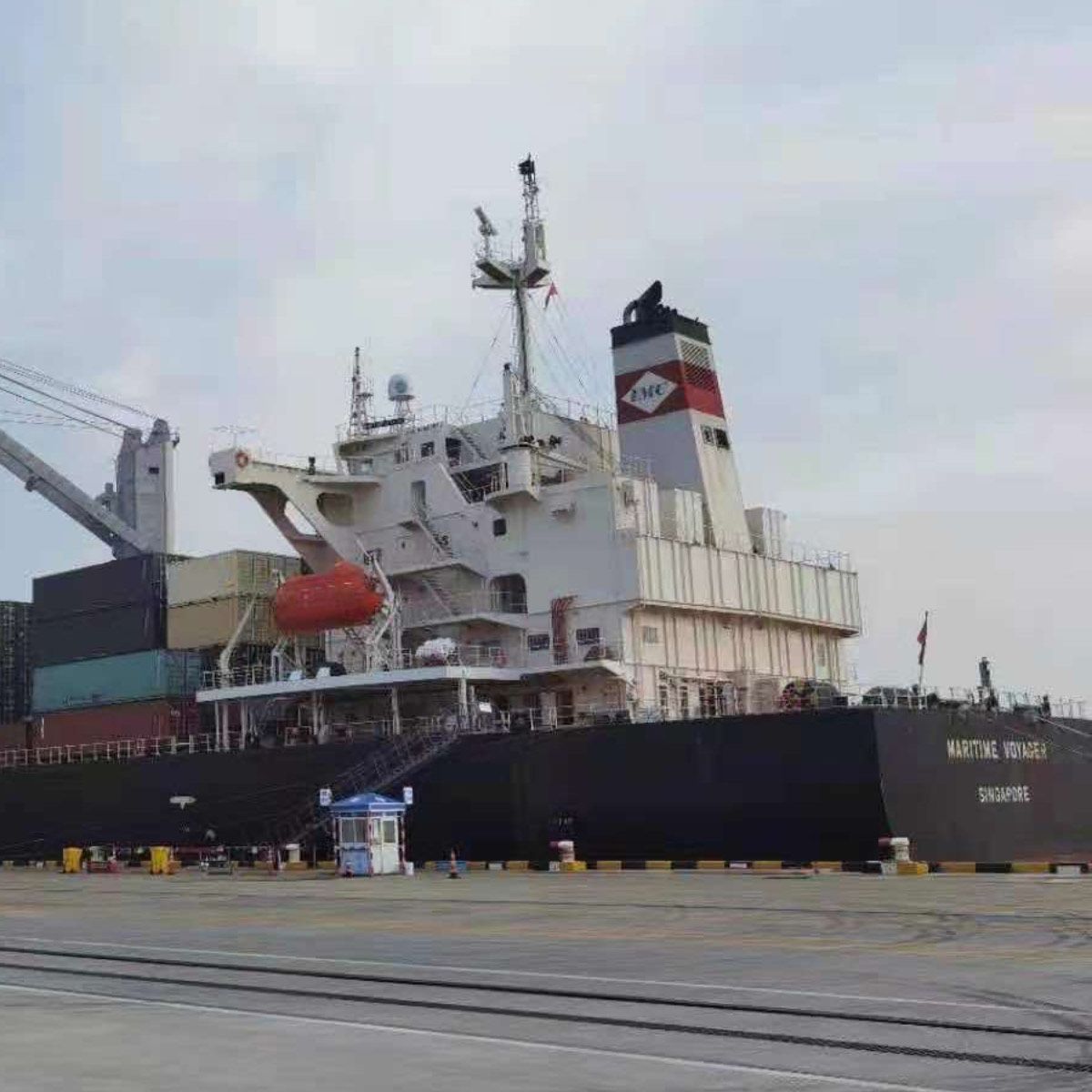 A container ship at berth with containers on deck