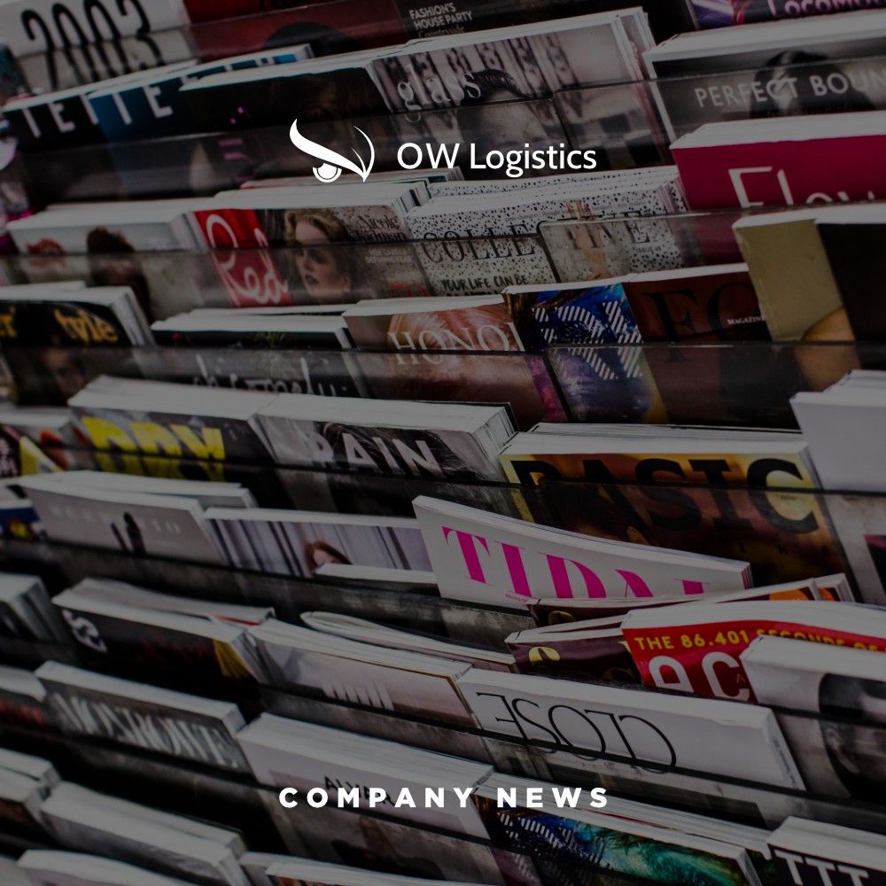 A rack of magazines under an OW Logistics company news banner
