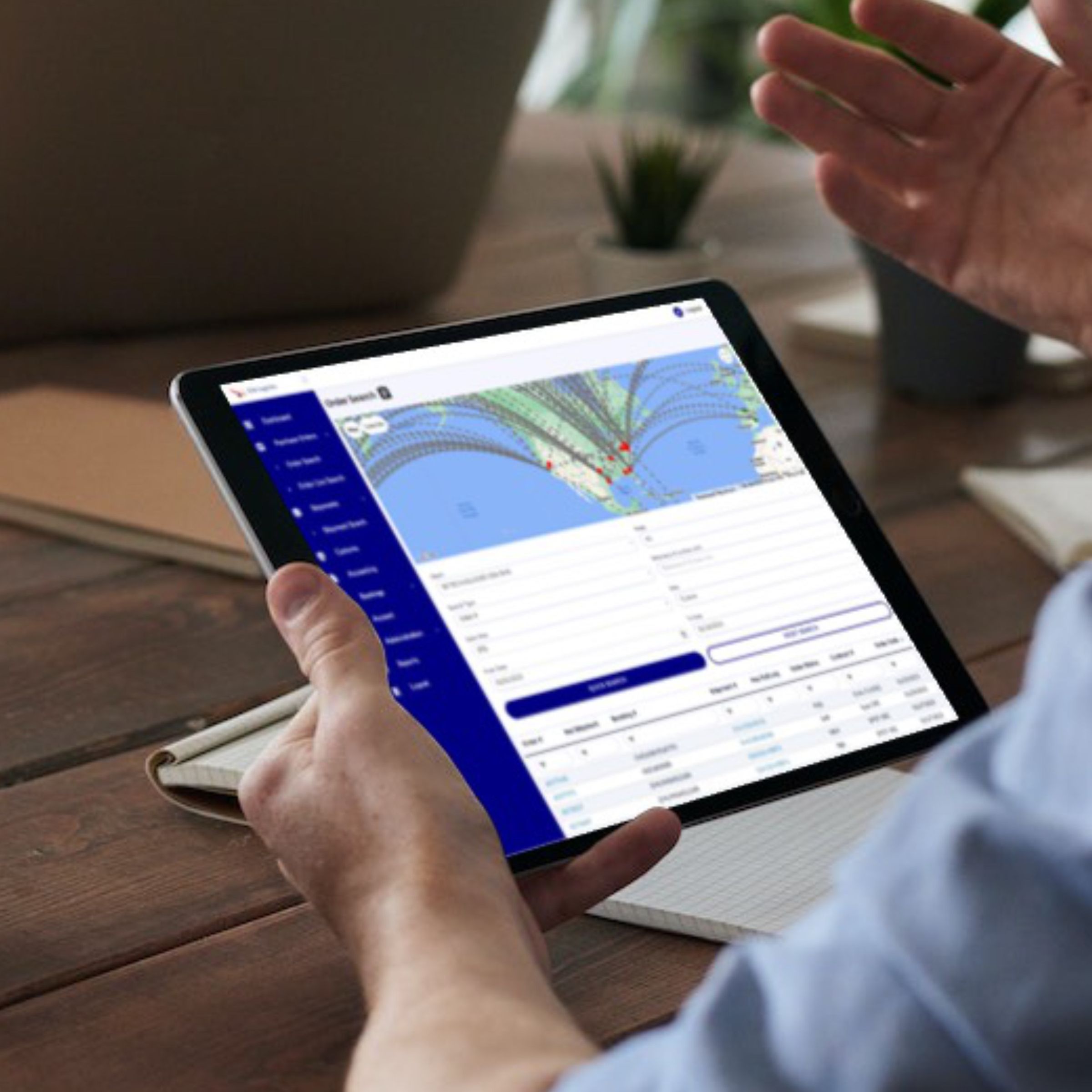 A hand holding a tablet showing the OWL Vision platform beside a cup of coffee