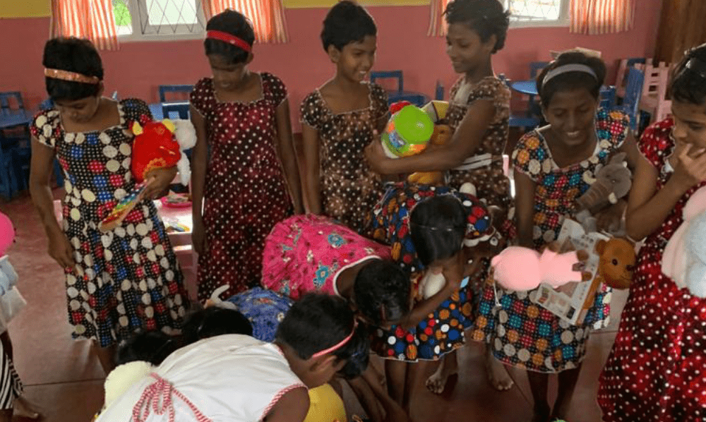 Children at an orphanage visited on the OWL tour, gathered with gifts and toys
