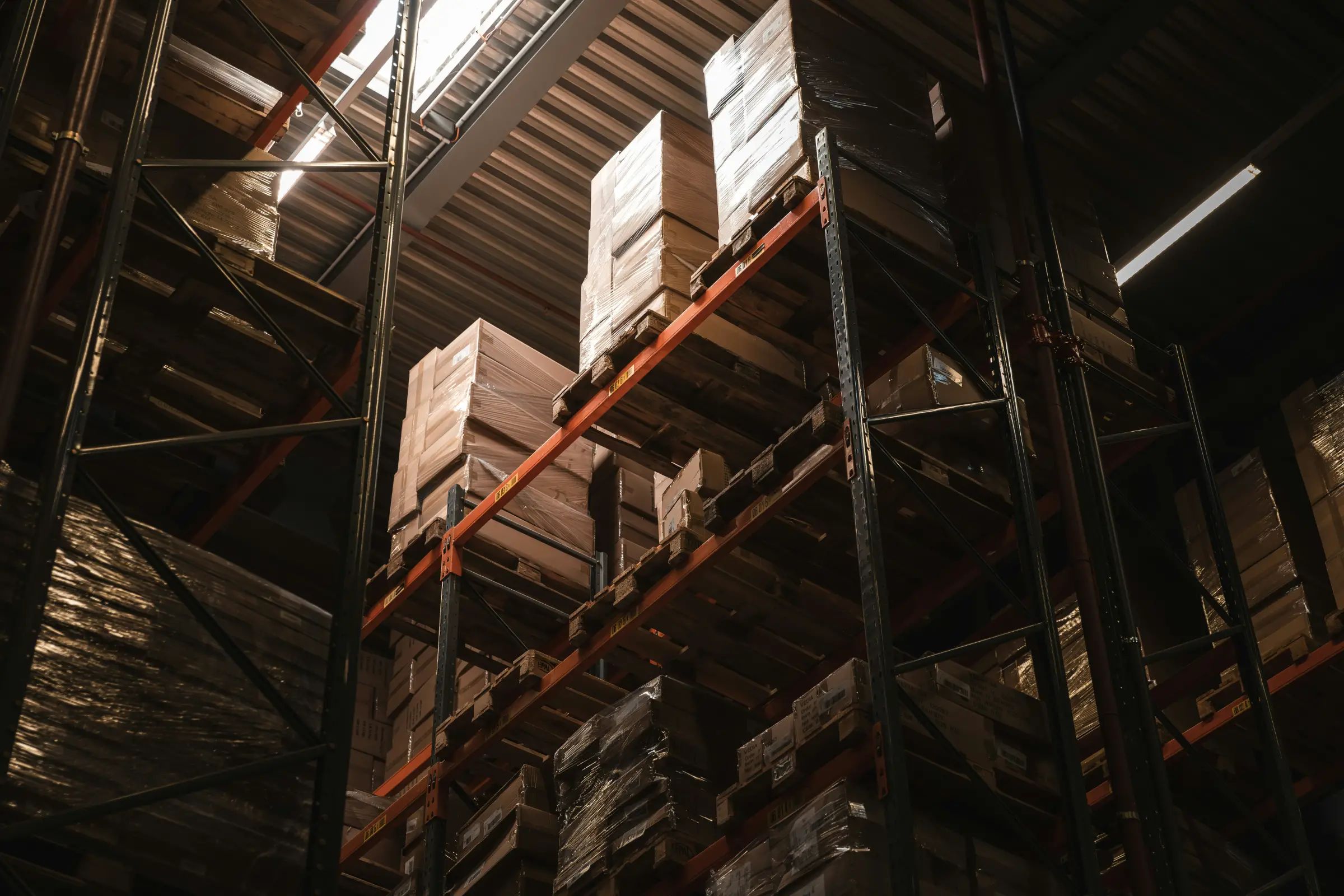 Looking up at warehouse racking stacked with boxed pallets